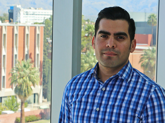 Photo of Marco Ortiz in front of a window overlooking campus