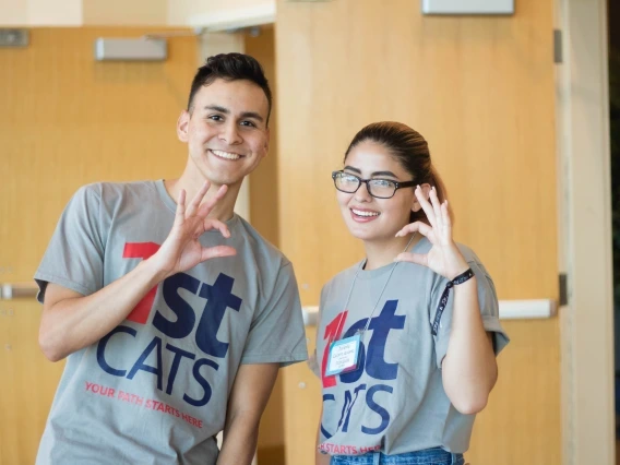 Two First Cats doing the Wildcat Symbol.