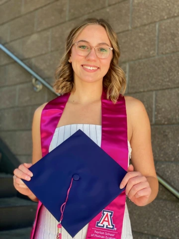 Student - Esther Perry- Standing with a graduation cap